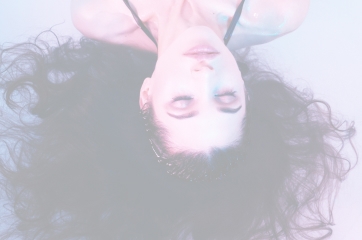 Faded background image of a woman laying in water with her hair floating in all directions.