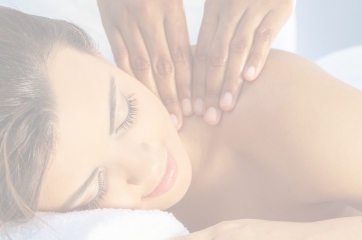 Faded background image of a woman getting a massage.  She is laying with her neck to the side and has hands on the back of her neck.